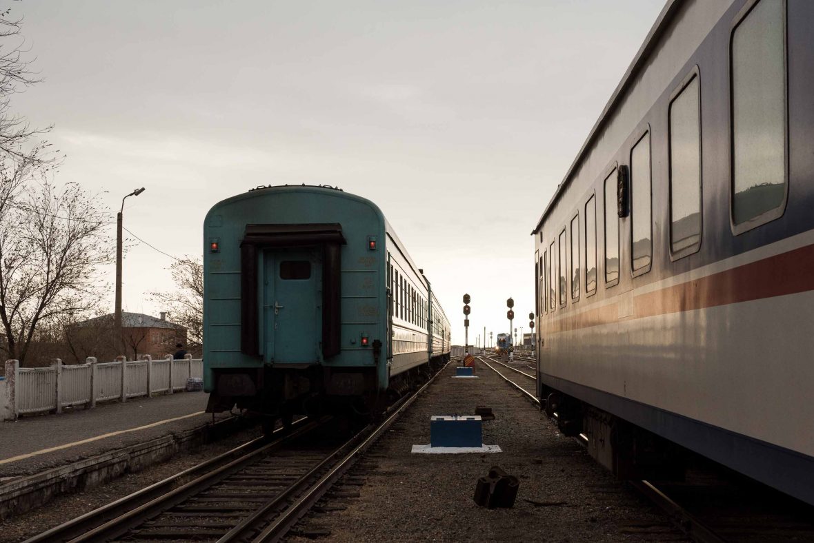 Trains pass each other in the dim light of day.