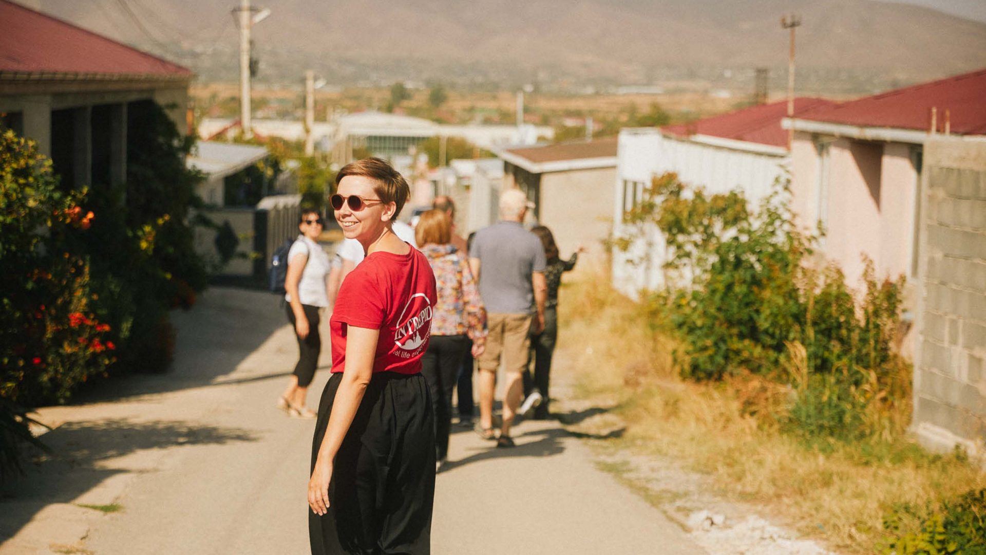 An Intrepid guide and her group walk through a town.