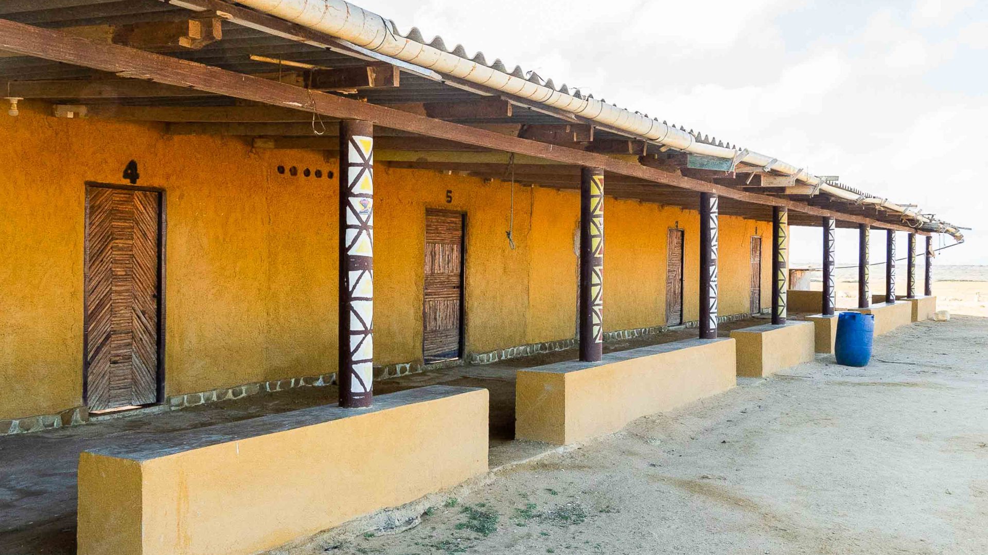 A yellow building with wooden doors which offers accomodation to travellers.