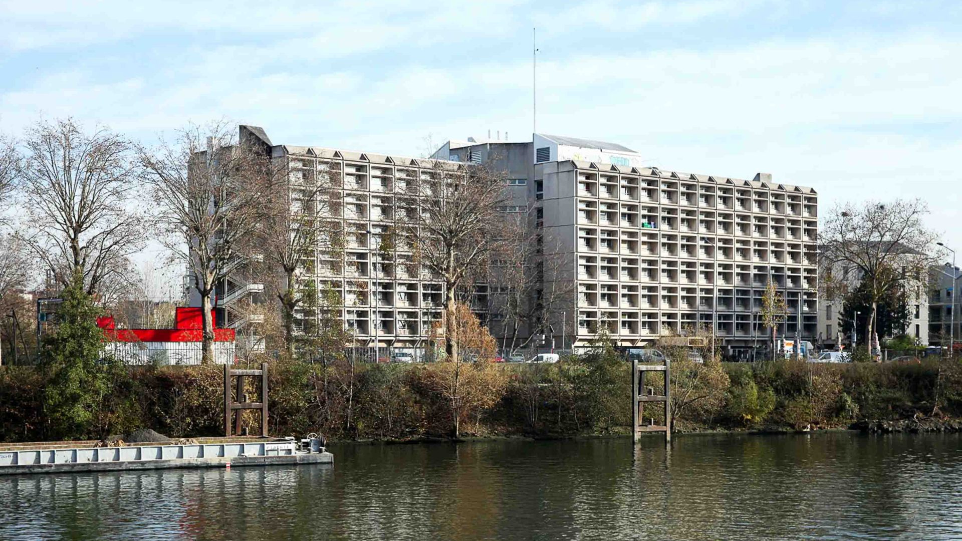 A large building sits on the edge of the river.