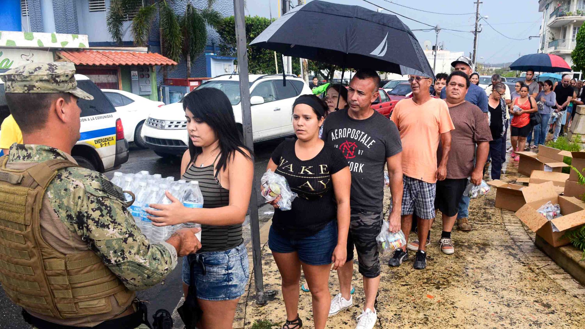 Water is delivered as aid to a line of people impacted by the hurricane.