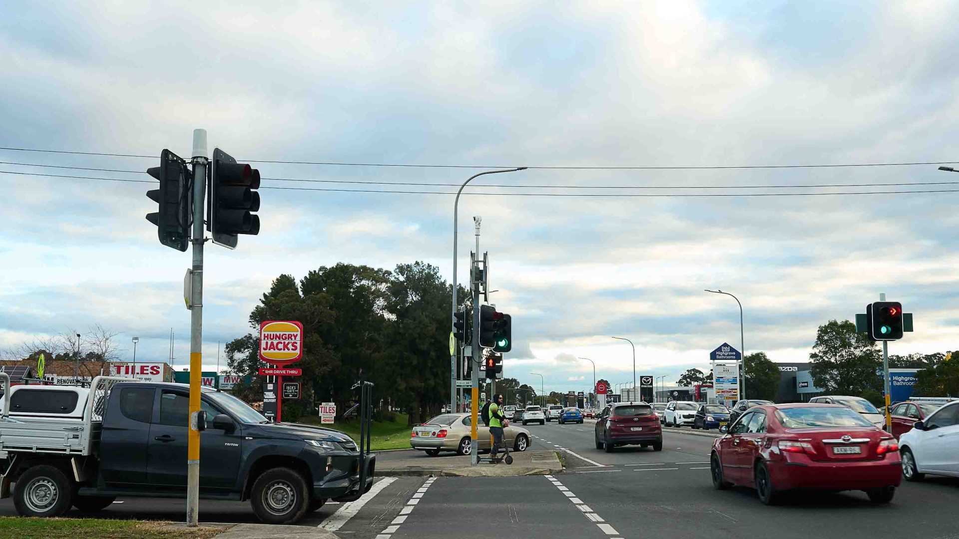 A busy road with fast food chains and cars.