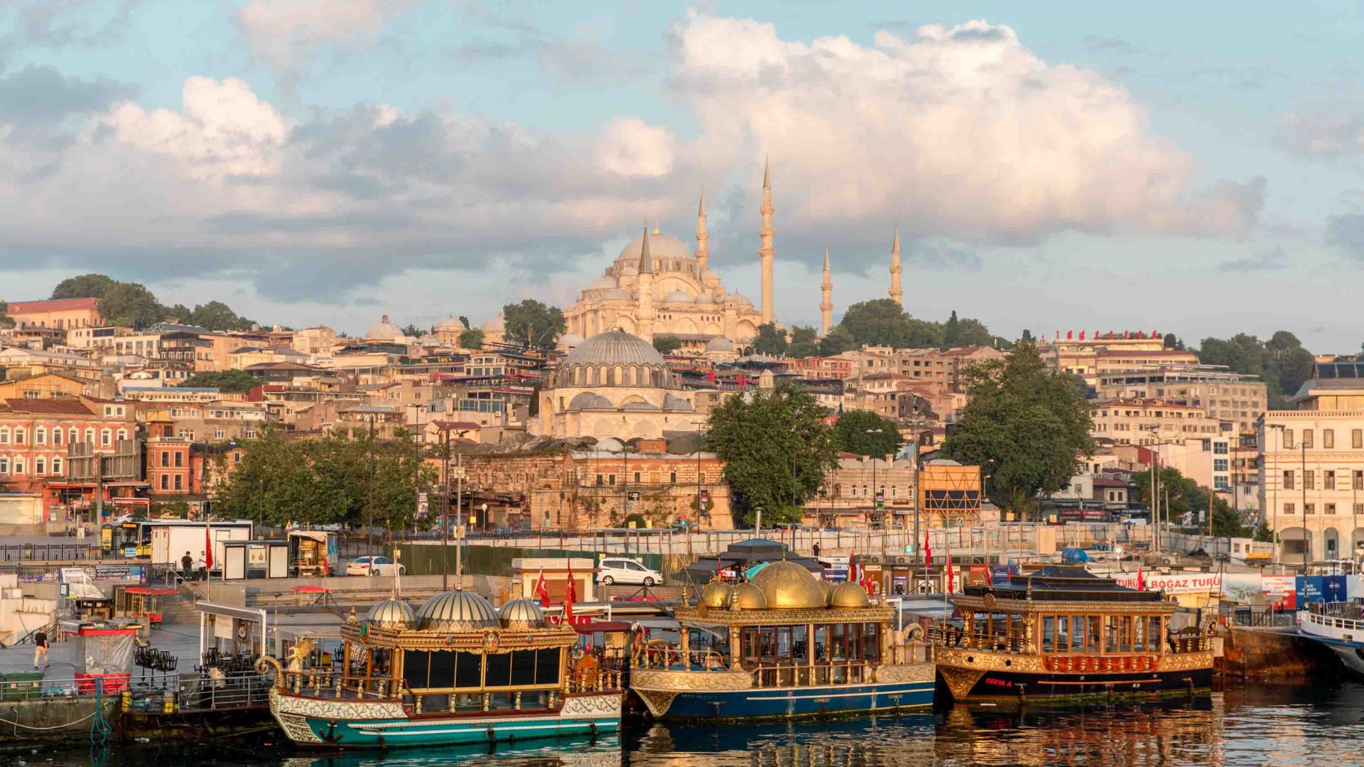 Looking at Istanbul from Galata Bridge. There are buildings, mosques and boats.